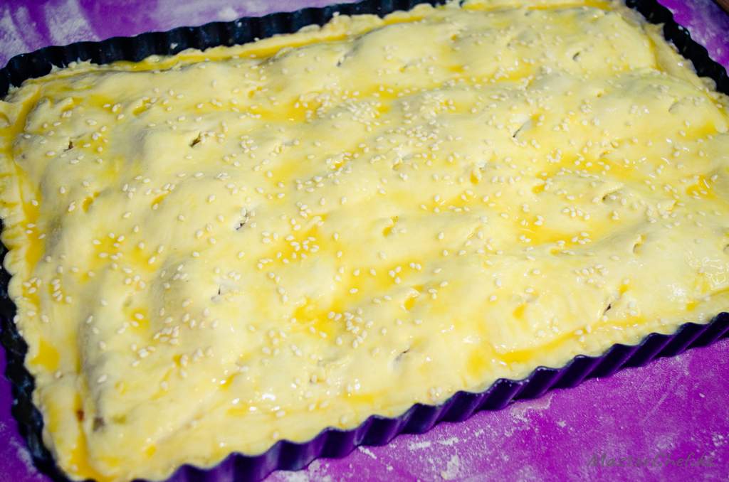 Раскатываем меньший кусочек теста и накрываем пирог, зажимаем края. Смазываем желтком и, по желанию, посыпаем кунжутом. Выпекаем при 180 гр 40-50 минут.